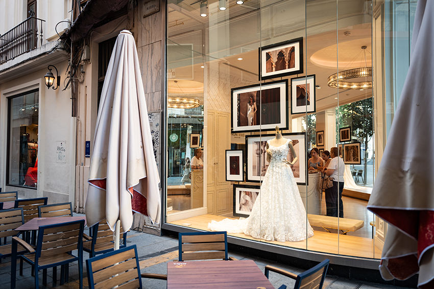 Bruidswinkel-etalage met drie vrouwen binnen; voorbeeld van storytelling in evenementenfotografie Haarlemmermeer.