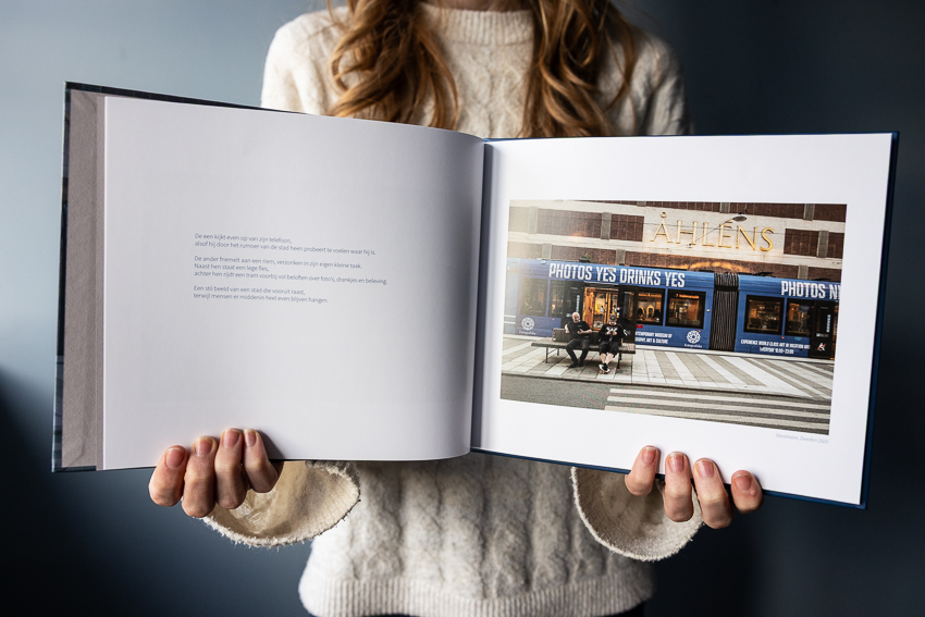 Documentaire straatfotografie van mensen op een bankje terwijl het stadsleven voorbijrijdt – beeld uit het fotoboek ‘Tijd die niet terugkeert, verhalen uit het alledaagse’ van documentaire fotograaf Martine Goulmy.